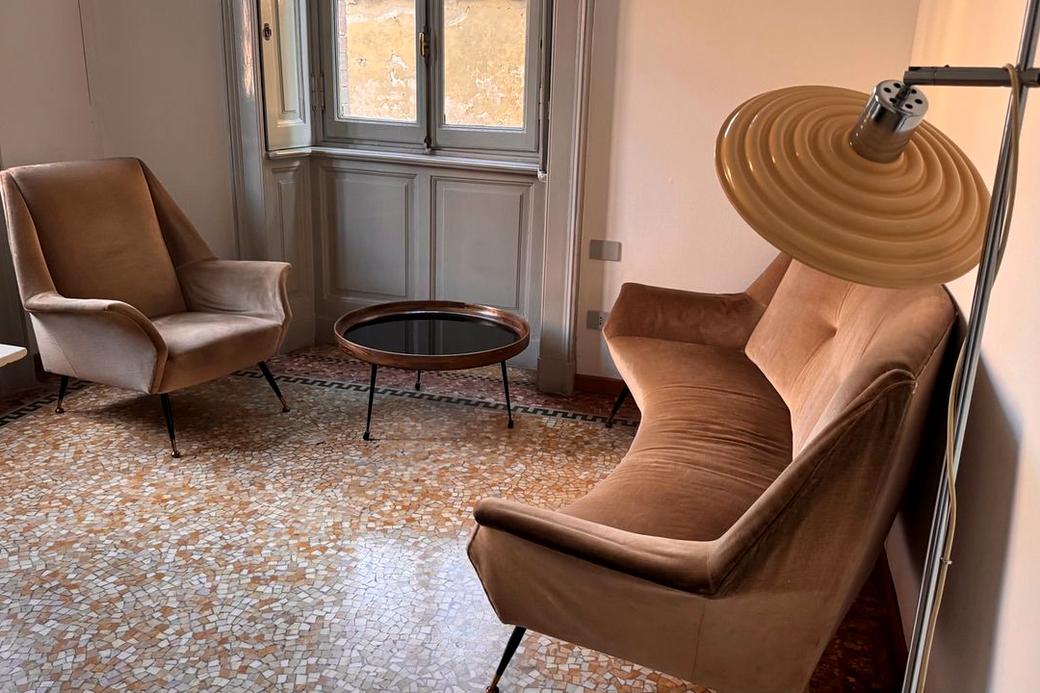 La sala dello studio con poltrone calde e pavimento in terrazzo, luce naturale